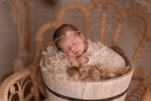 bébé qui dort dans une bassine en bois